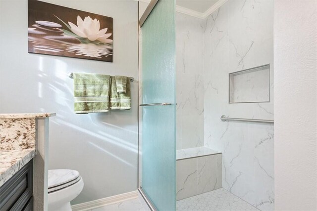 bathroom featuring toilet, marble finish floor, a marble finish shower, crown molding, and vanity