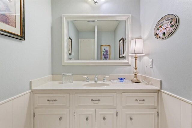 bathroom featuring a wainscoted wall and vanity