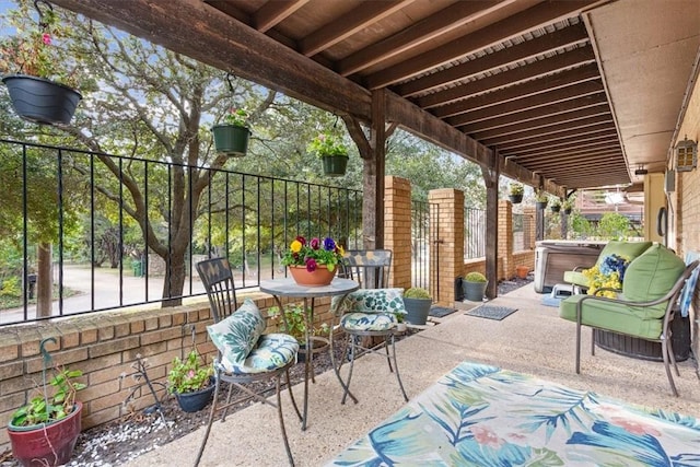 view of patio / terrace featuring a hot tub and fence