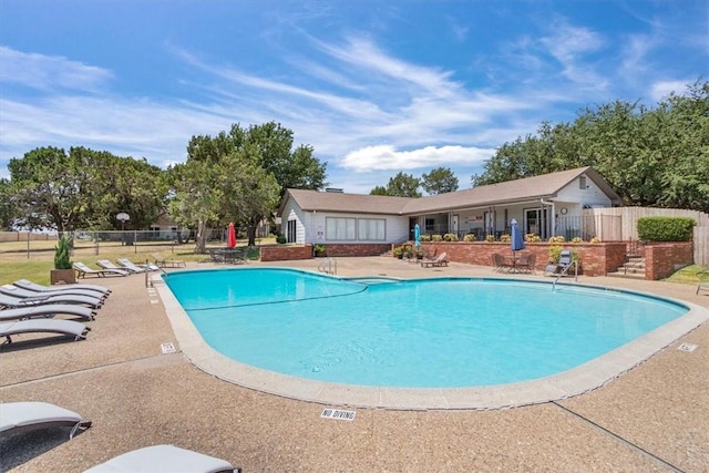 pool with a patio and fence