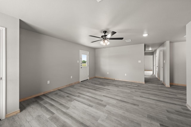 unfurnished living room with a ceiling fan, baseboards, visible vents, and wood finished floors