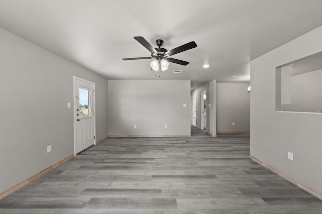 unfurnished living room featuring baseboards, ceiling fan, and wood finished floors