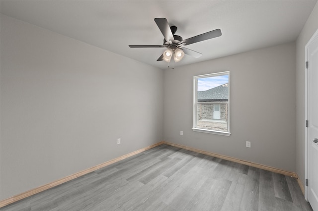 unfurnished room with baseboards, ceiling fan, and light wood finished floors