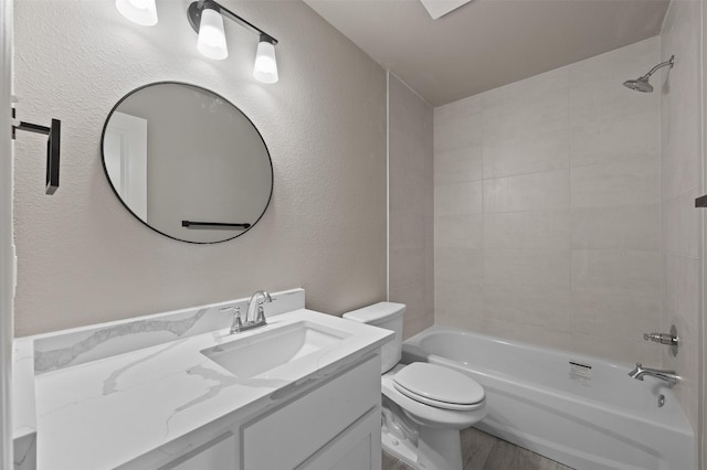 bathroom with a textured wall, vanity, toilet, wood finished floors, and  shower combination