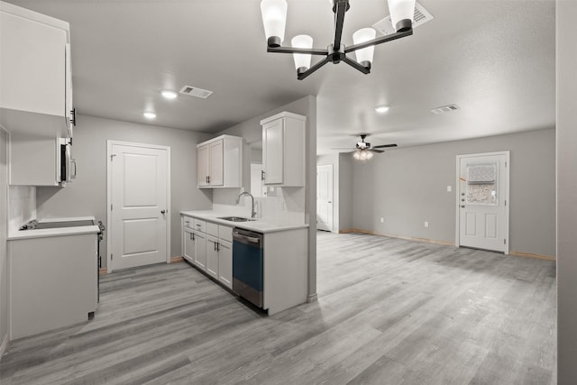kitchen featuring visible vents, a sink, dishwashing machine, and light wood-type flooring