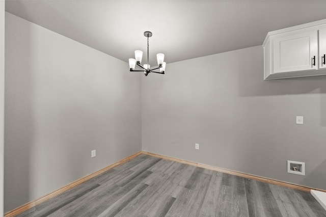 unfurnished dining area with light wood-style floors, baseboards, and a notable chandelier