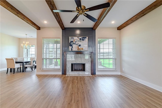 unfurnished living room with plenty of natural light, baseboards, and wood finished floors