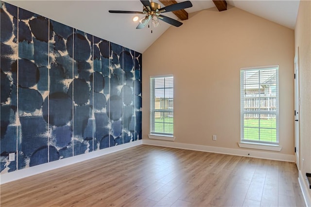 unfurnished room with high vaulted ceiling, wood finished floors, a wealth of natural light, and ceiling fan