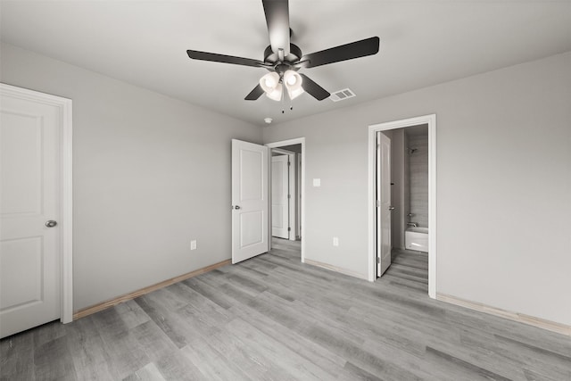 unfurnished bedroom featuring baseboards, ensuite bath, light wood-style flooring, and visible vents
