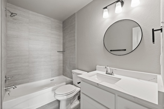 full bathroom featuring vanity, a textured wall, washtub / shower combination, and toilet