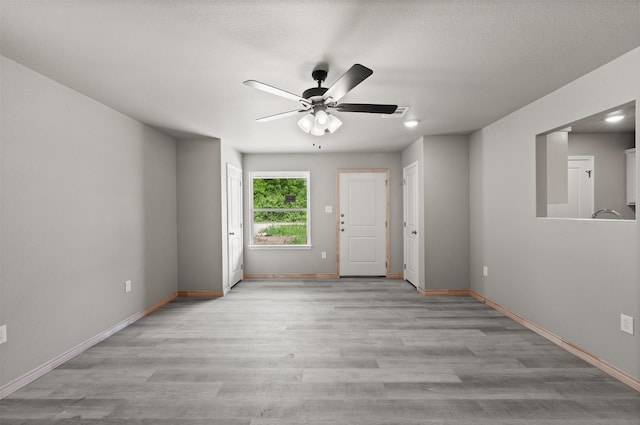 empty room featuring baseboards, ceiling fan, and wood finished floors
