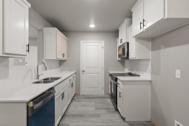 kitchen with a sink, light wood finished floors, light countertops, stainless steel appliances, and decorative backsplash