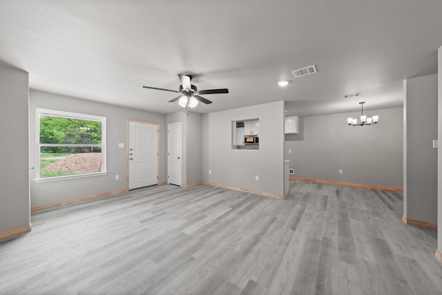 unfurnished living room with visible vents, baseboards, ceiling fan with notable chandelier, and light wood-style floors