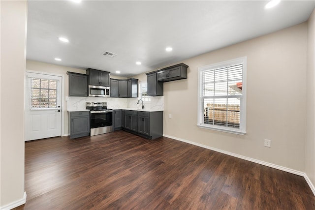 2713 Woodrow St, Waco, TX 76708 - kitchen with stainless steel appliances, dark wood finished floors, baseboards, light countertops, and recessed lighting