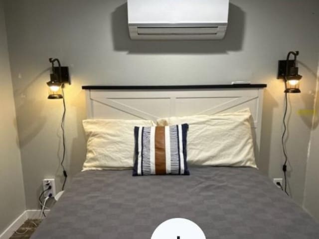 bedroom featuring a wall mounted AC and baseboards