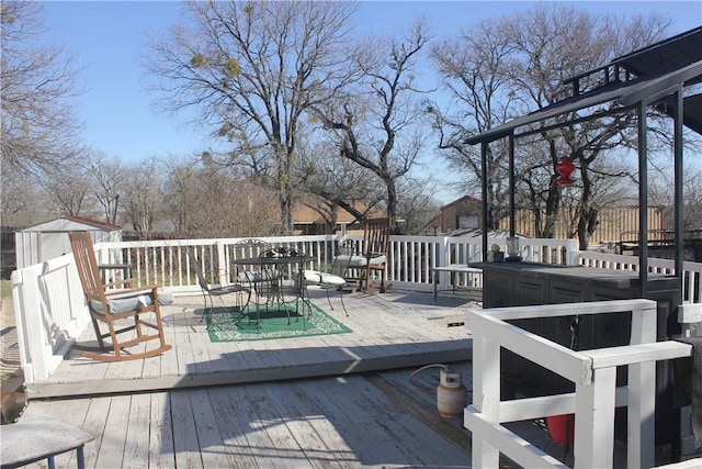 wooden deck with an outdoor structure and outdoor dining space