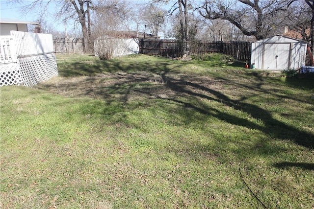 view of yard featuring an outdoor structure, a fenced backyard, and a shed