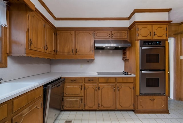 kitchen with under cabinet range hood, appliances with stainless steel finishes, brown cabinetry, crown molding, and light countertops