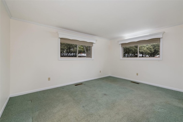 unfurnished room with a wealth of natural light, visible vents, carpet flooring, and ornamental molding
