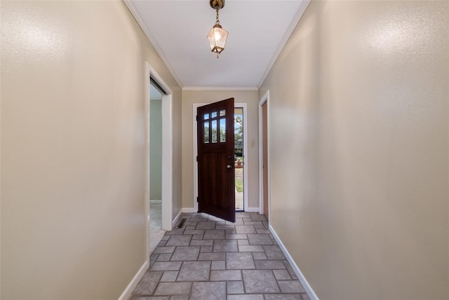 entryway featuring stone finish floor, crown molding, and baseboards