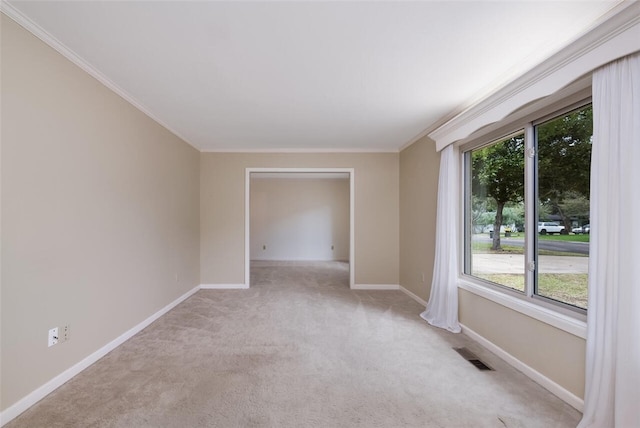 unfurnished room featuring light carpet, baseboards, visible vents, and ornamental molding