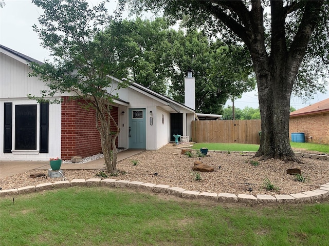 707 Cherry Dr, Groesbeck, TX 76642 - rear view of property with a chimney and brick siding