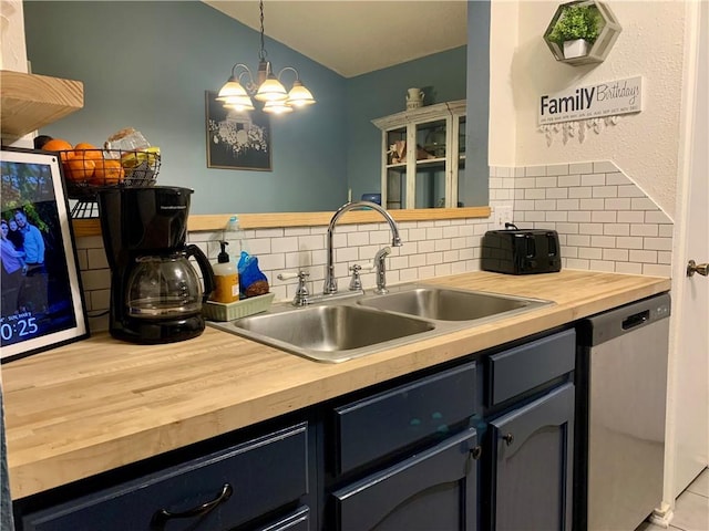 kitchen with a sink, butcher block counters, decorative backsplash, and stainless steel dishwasher