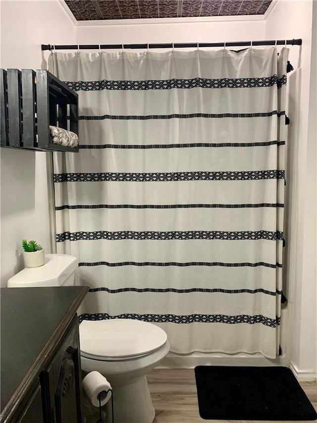 bathroom with curtained shower, vanity, toilet, and wood finished floors