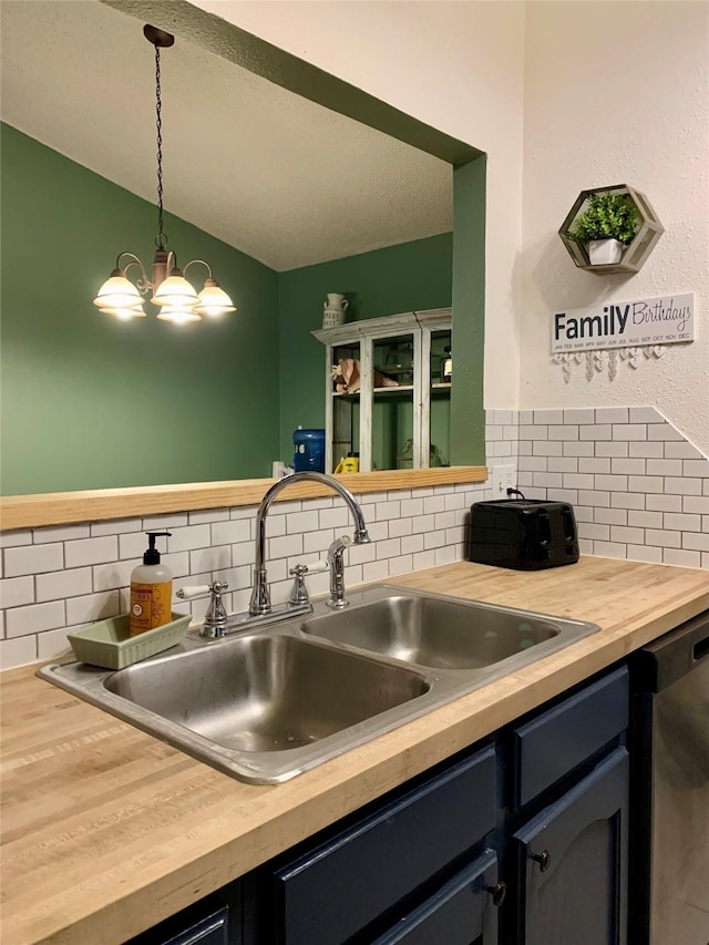 707 Cherry Dr, Groesbeck, TX 76642 - kitchen with butcher block countertops, a sink, decorative backsplash, and stainless steel dishwasher