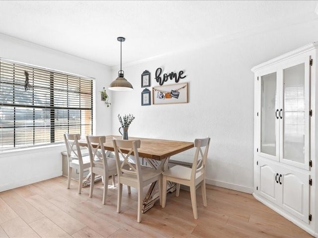 dining area featuring baseboards and light wood-style flooring