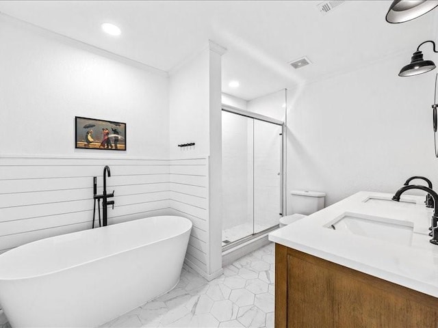 full bathroom with a wainscoted wall, visible vents, a stall shower, a freestanding bath, and a sink