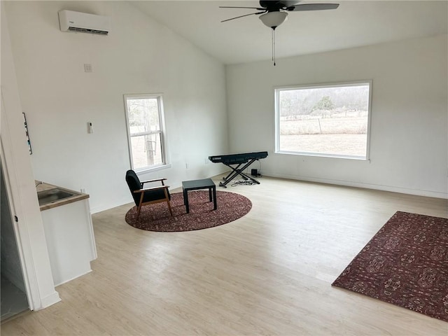 sitting room with baseboards, a wall mounted air conditioner, wood finished floors, high vaulted ceiling, and a ceiling fan