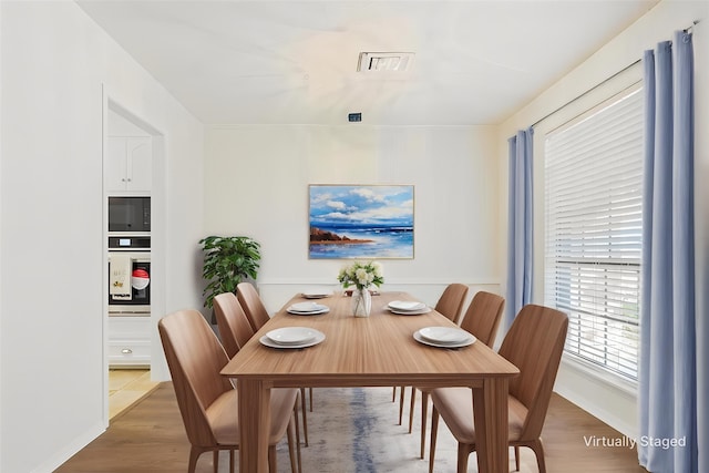 dining room with visible vents and wood finished floors