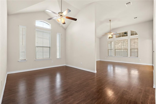 empty room featuring a ceiling fan, baseboards, visible vents, high vaulted ceiling, and dark wood-type flooring