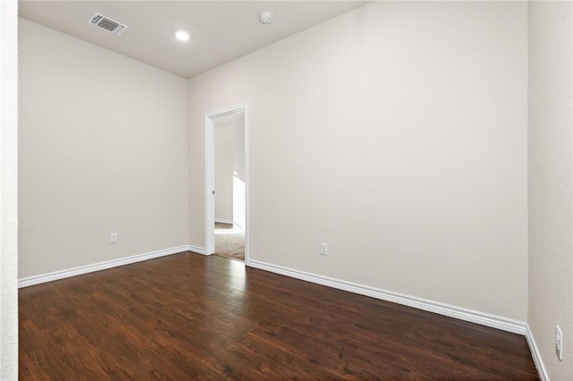 empty room featuring recessed lighting, visible vents, baseboards, and dark wood-style floors