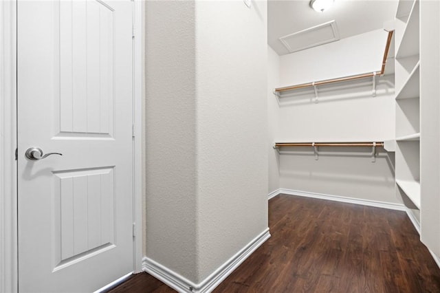walk in closet featuring attic access and wood finished floors