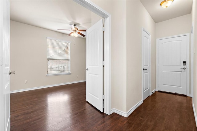 corridor with dark wood-type flooring and baseboards