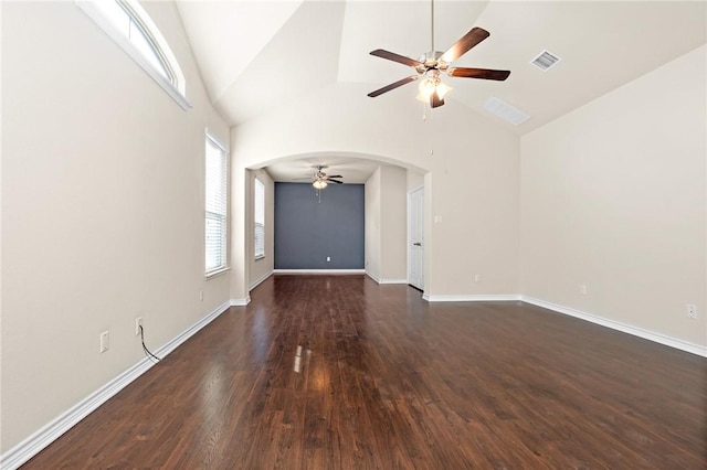 unfurnished living room featuring visible vents, dark wood-style floors, arched walkways, baseboards, and ceiling fan