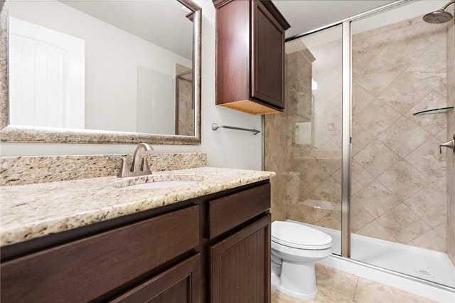 bathroom featuring toilet, a stall shower, vanity, and tile patterned flooring
