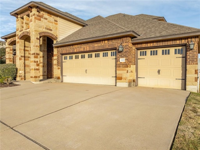 view of front of property with concrete driveway, an attached garage, brick siding, and roof with shingles