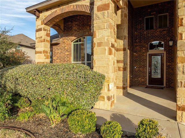 property entrance with brick siding and stone siding
