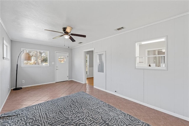empty room featuring visible vents, crown molding, a ceiling fan, and tile patterned flooring