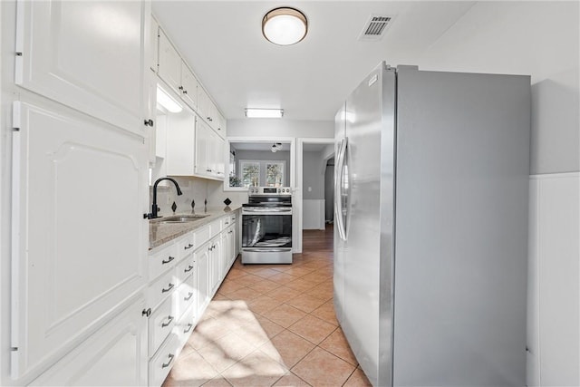 kitchen with light tile patterned floors, visible vents, a sink, appliances with stainless steel finishes, and white cabinetry