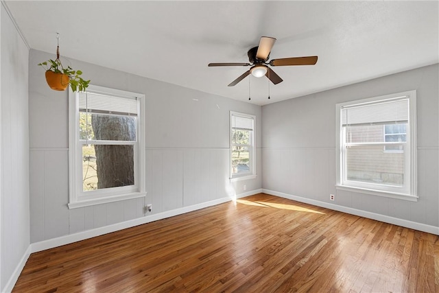 spare room featuring baseboards, ceiling fan, and hardwood / wood-style flooring