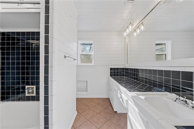 bathroom featuring tile patterned flooring, decorative backsplash, and vanity