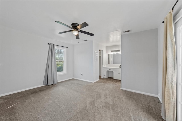 unfurnished bedroom with visible vents, connected bathroom, baseboards, carpet flooring, and a ceiling fan
