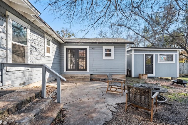 rear view of property with french doors, a patio, and an outdoor structure