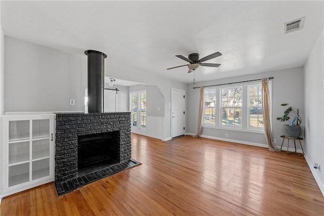 unfurnished living room featuring light wood-style flooring, baseboards, visible vents, and ceiling fan
