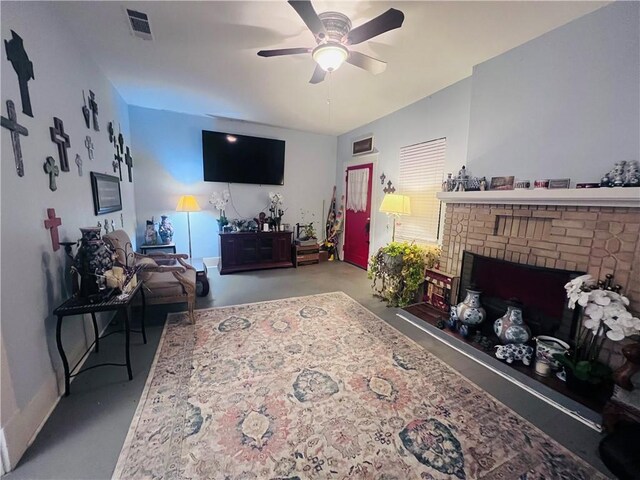 living area with visible vents, a fireplace, concrete floors, and a ceiling fan
