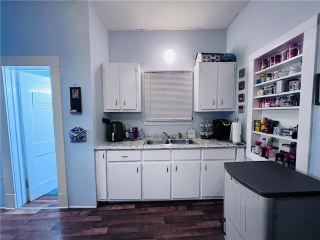 kitchen with a sink, dark wood finished floors, light countertops, white cabinets, and open shelves